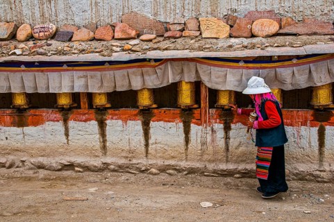 Old woman turning the prayer wheels in the kingdom of Guge