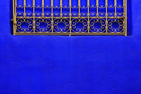 Ornate window grille in a blue wall