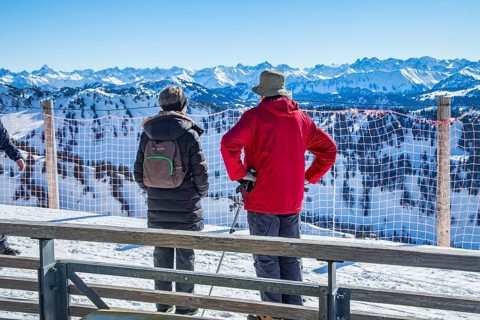 Senior holidaymaker couple admires mountain panorama
