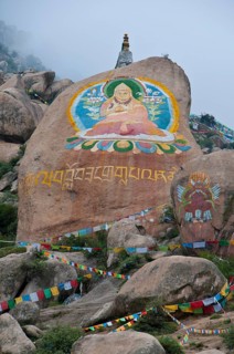 Huge Buddha painted on a rock behind the Drepung temple