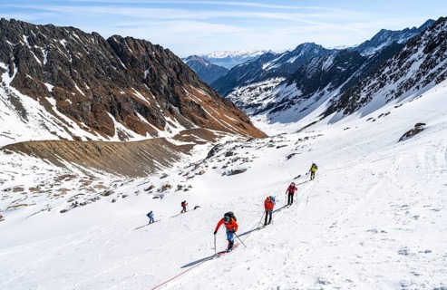 Group of ski tourers walking on the rope on the glacier