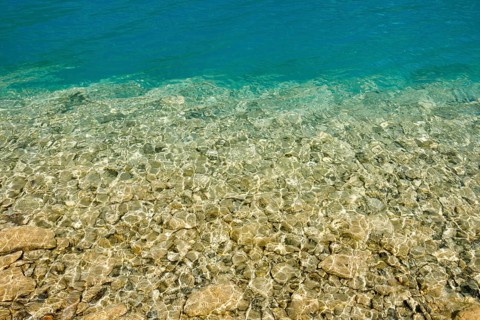 Fascinating play of colours and shapes of the clear water of Lake Walen at the edge of the shore