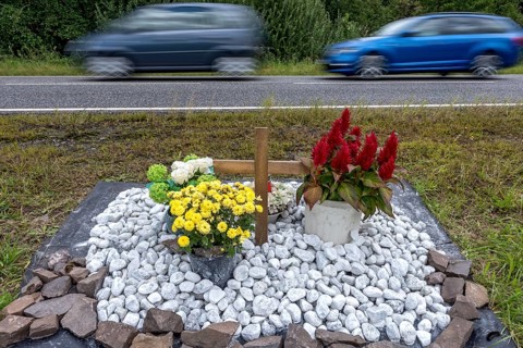 Memorial with cross for victims of road accident on country road