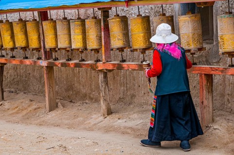 Old woman turning the prayer wheels in the kingdom of Guge