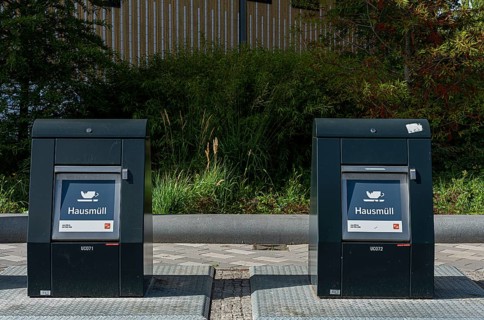 Modern household waste containers in front of new buildings in Europacity