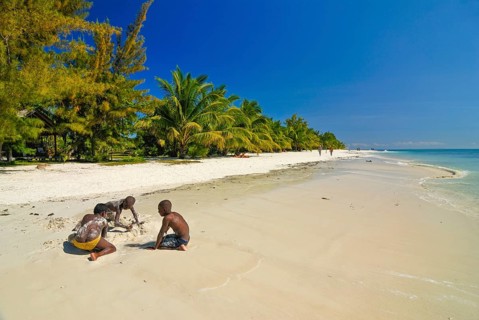 Children playing on a white sand beach on Iles aux Nattes near Ile saint marie