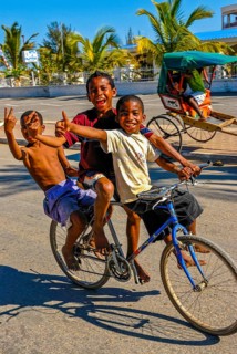 Happy boys cycling through the streets of Toliara