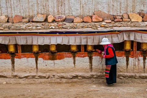Old woman turning the prayer wheels in the kingdom of Guge