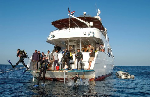 Divers jump from dive deck of dive ship for dive cruise into sea water