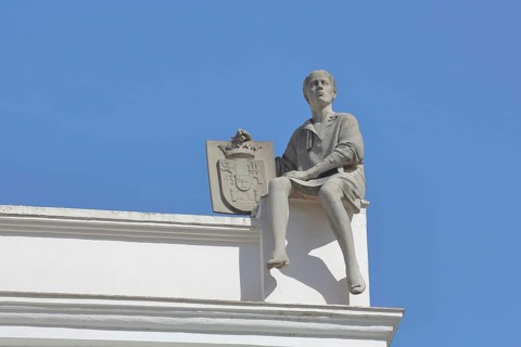 Sculpture figure with coat of arms on the roof of Asamblea Regional