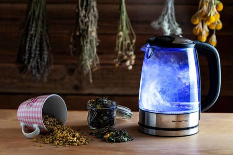 Electric kettle on wooden table with teas