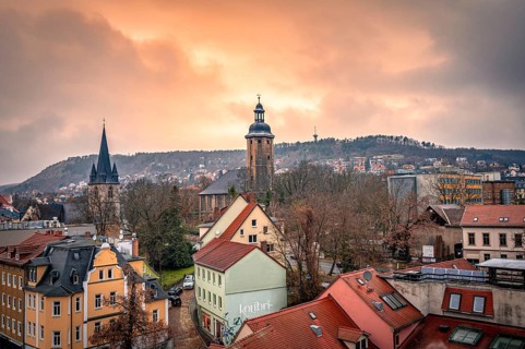 View of the Friedenskirche in the centre of Jena with the Landgrave in the background at sunset