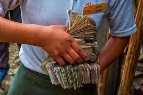 Woman holds bundles of Yuan
