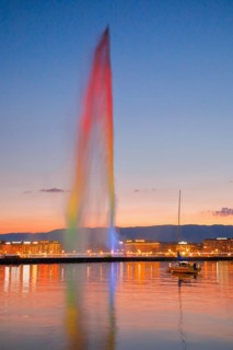 The illuminated Jet d'eau at dusk is the landmark in the Lake Geneva basin