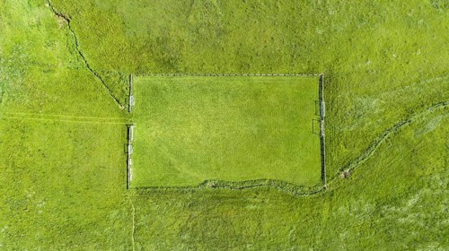 Aerial view of a football field in the Allgaeu region with a stream as a sideline