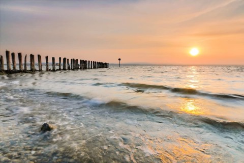 Golden sunrise on the shore of Lake Constance with jetty near Altnau in the canton of Thurgau