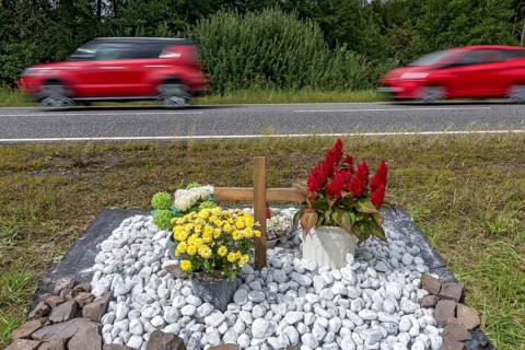 Memorial with cross for victims of road accident on country road
