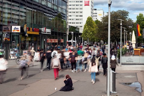 Beggar woman in the pedestrian zone Prager Strasse in the city centre