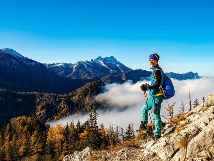 Mountaineer above forest line and clouds enjoying the view