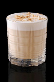 Cappuccino or latte with hazelnut crumbs on black background with reflection