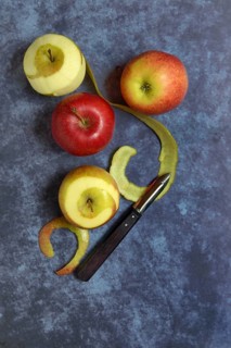 Peeled apples with peeling knife