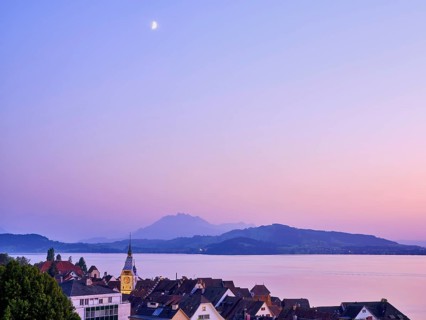 Illuminated Zytturm with old town on Lake Zug