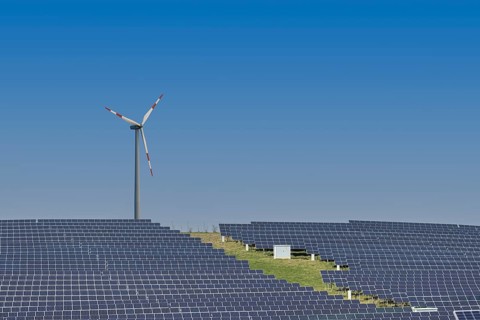 Solar plant with wind turbine in the background