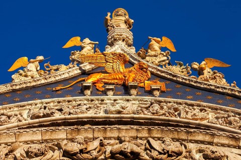 Gilded God the Father with angels and St. Marks lion on the gable of St. Marks Basilica