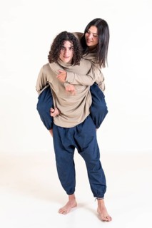 Brother and sister twins matching outfits. A handsome teenager carrying his beautiful sister on his back