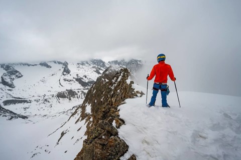 Ski tourers on rocky ridge with snow