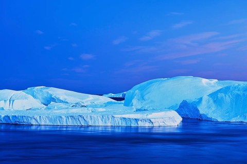 Gigantic icebergs in the light of the blue hour