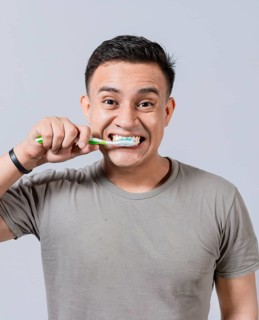 Face of handsome man brushing his teeth. Tooth brushing and care concept. Face of guy brushing teeth isolated. Oral and dental smile concept