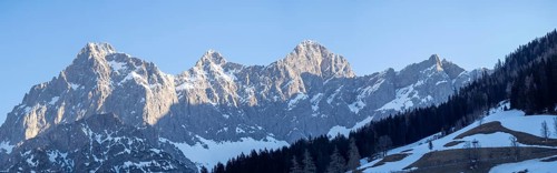 Blue sky above snowy alpine peak