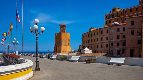 Lighthouse next to houses in pastel-coloured facades