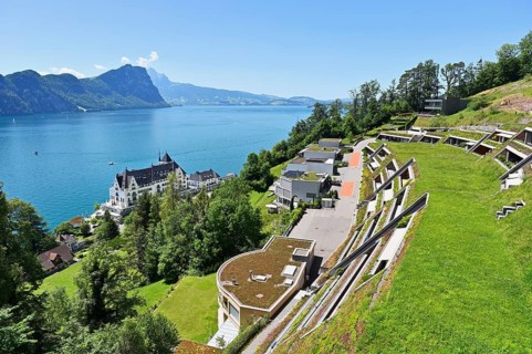 Modern earth houses built on a slope with a view of the Parkhotel and Lake Lucerne