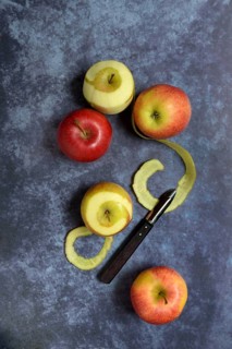 Peeled apples with peeling knife