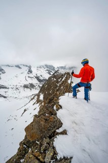 Ski tourers on rocky ridge with snow
