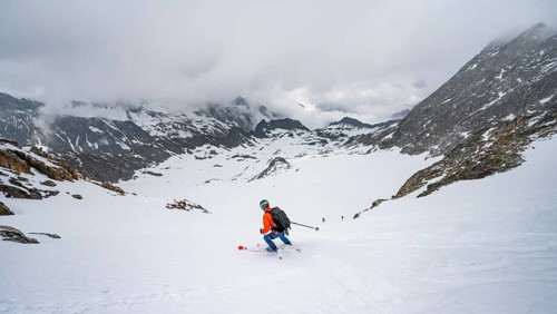Skiers skiing downhill on the Sommerwandferner glacier