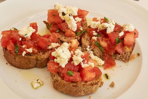 Plate of bruschetta with tomatoes and feta