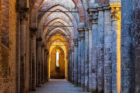 Side aisle of the ruined church of San Galgano Abbey in the evening light