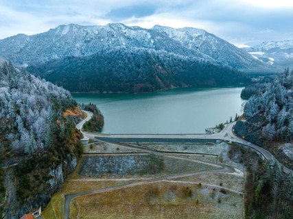 Road with dam on the water in winter
