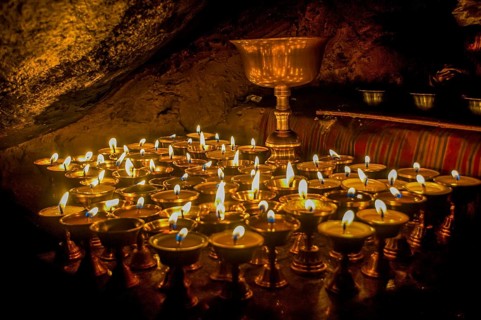 Cave with candles and Buddha images along the Kailash Kora