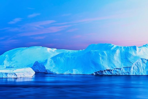 Gigantic icebergs in the light of the blue hour