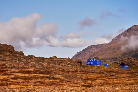 Blue wooden houses standing in volcanic landscape