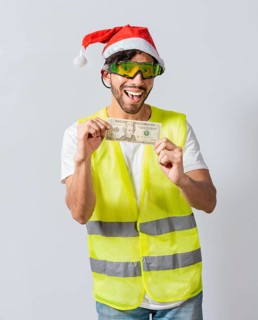 Happy builder engineer with christmas hat holding one dollar bill isolated. Happy christmas engineer showing one dollar bill