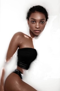 Beautiful african american woman with classic makeup in milk bath. Beauty face