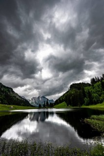 Groeppelensee with reflection of the Altmann summit in the background under a threatening cloudy sky