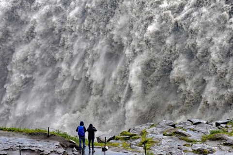 People in front of falling water masses