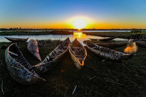 Fisherman repairs his net at sunset