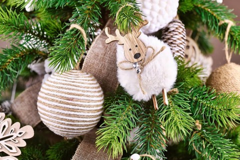 Natural Christmas tree ornament bauble made from beige and white jute rope and sheep ornament on tree branches